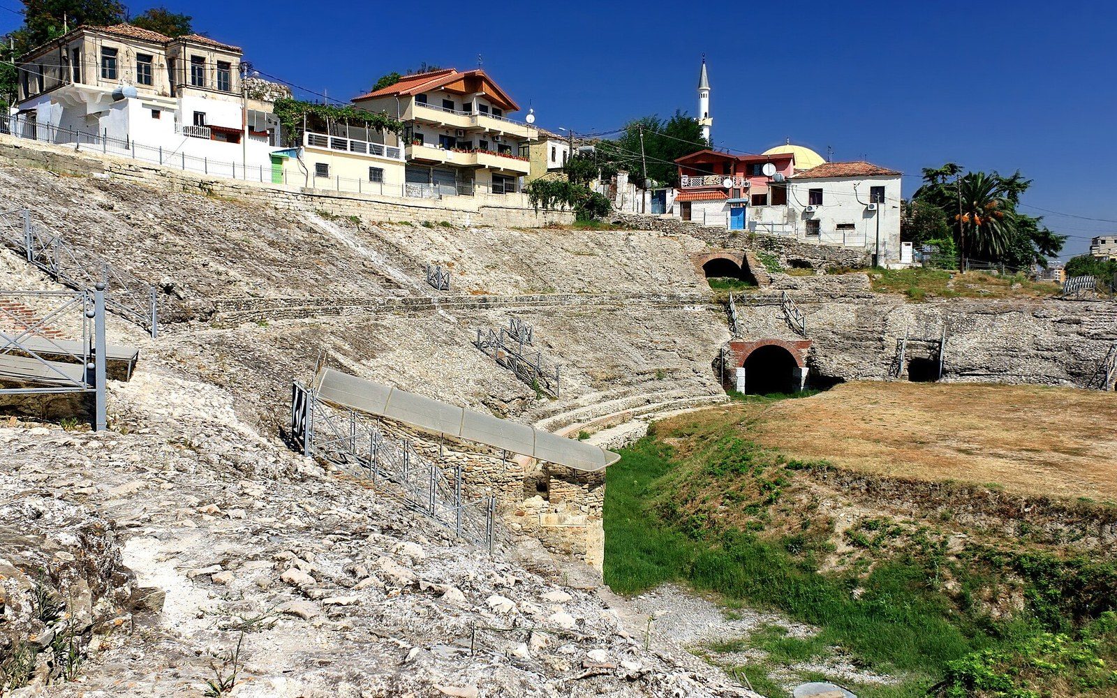 An excavated amphitheatre with modern apartment blocks built up to its rim